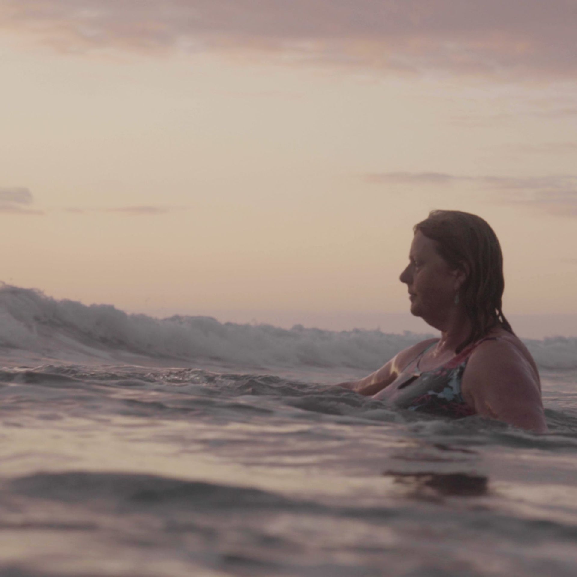 Sue Read swimming at sunset in the surf at Northcott Mouth