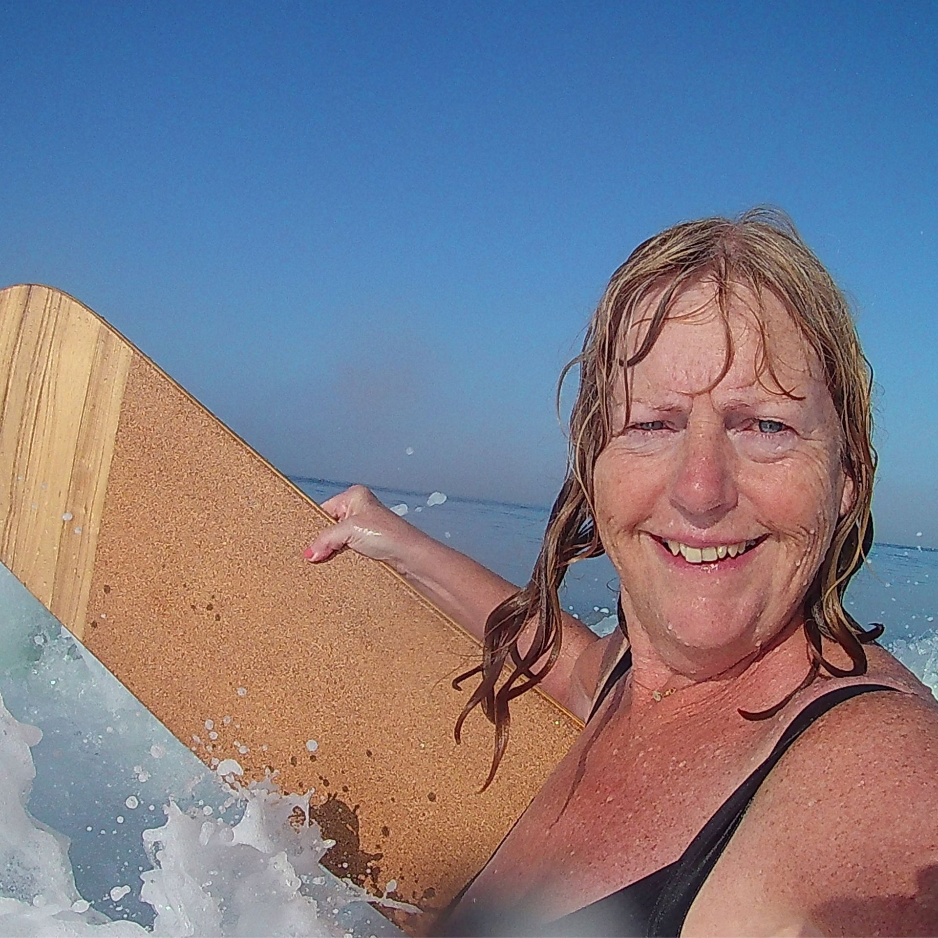 Sue Read with wooden bellyboard in the surf at Crooklets, Bude